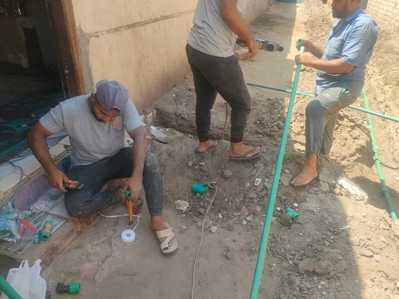 فريق العمل أثناء تركيب وصلة مياه منزلية ومدّ المواسير إلى داخل المنزل